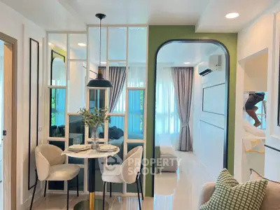 Modern open-plan living room with dining area, featuring stylish decor and natural light.