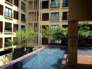 Luxurious apartment complex with serene pool and lush greenery