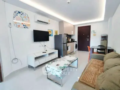 Modern living room with open kitchen, stylish decor, and cozy seating area.