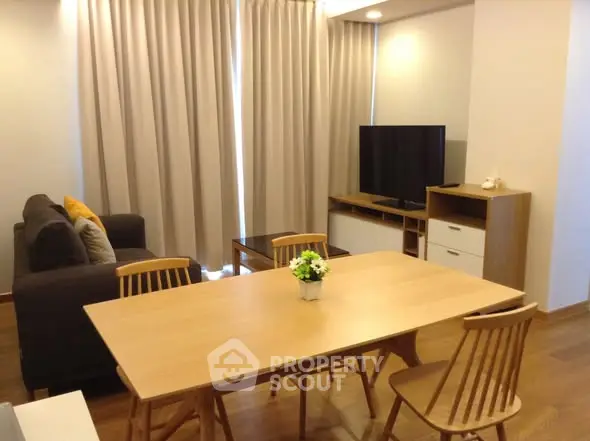 Modern living room with wooden furniture and large TV, perfect for cozy gatherings.