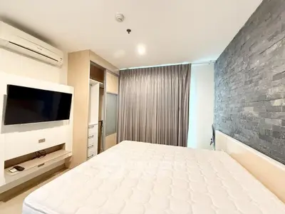 Modern bedroom with stone accent wall and built-in storage