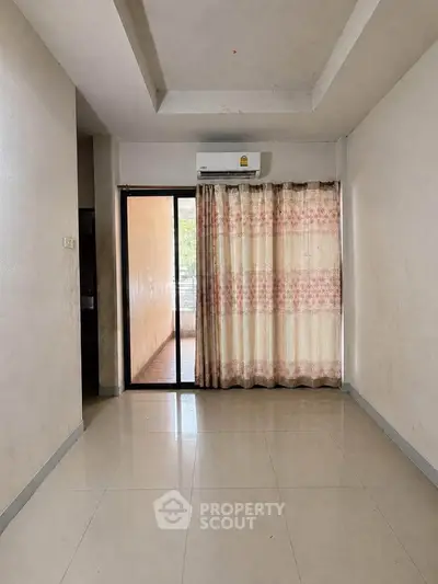 Spacious room with air conditioning and sliding glass door leading to balcony.