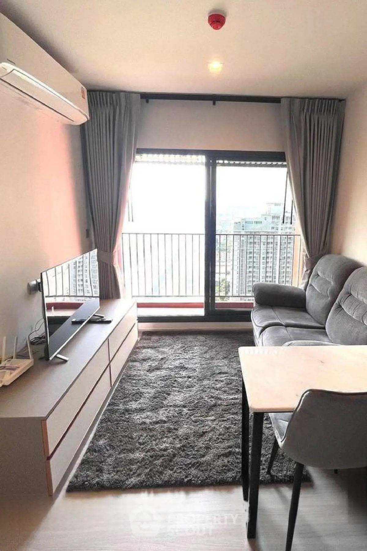 Modern living room with balcony view, featuring sleek furniture and abundant natural light.