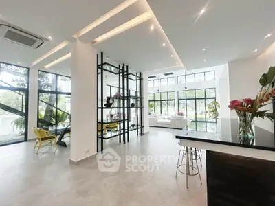 Spacious modern living room with large windows and stylish decor, perfect for luxury living.