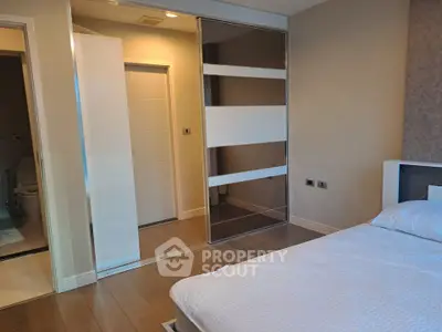 Modern bedroom with sleek sliding closet doors and cozy bed setup