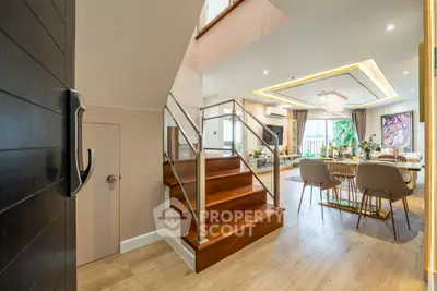 Luxurious open-plan living room with elegant dining area and modern staircase