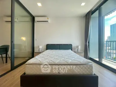 Spacious bedroom with large windows and balcony access in modern apartment