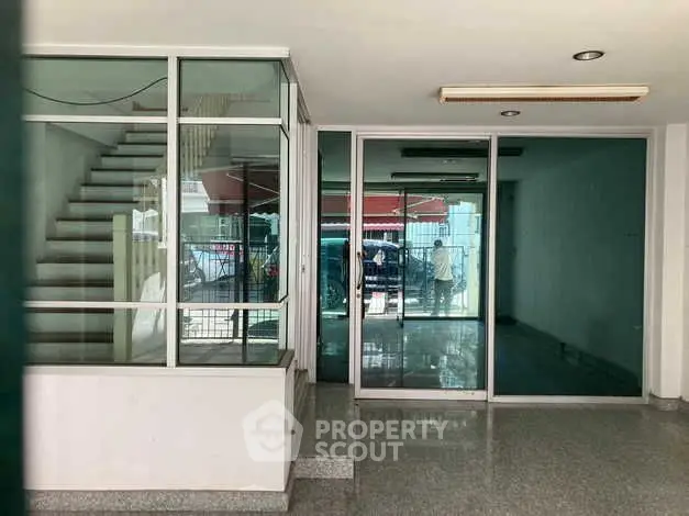 Spacious commercial property with glass doors and staircase, ideal for business setup.