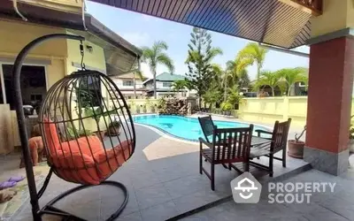 Inviting poolside patio with stylish hanging chair and ample seating, perfect for entertaining in a serene suburban setting.