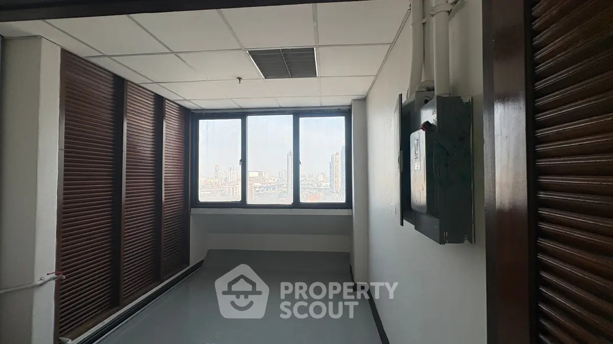 Spacious room with large window offering stunning city view, perfect for office or study space.