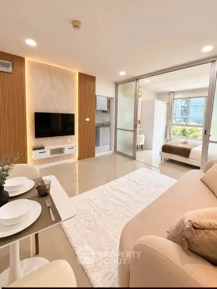 Modern open-plan living room with sleek design and cozy ambiance, featuring a stylish TV setup and elegant decor.