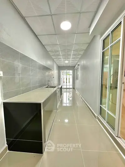 Sleek modern kitchen with closed layout and glossy tiles
