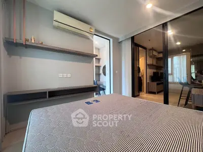 Modern bedroom with air conditioning and sliding glass doors leading to a cozy living area.