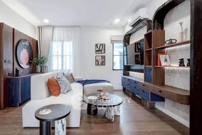Modern living room with stylish decor and contemporary furniture, featuring a cozy seating area and elegant shelving.