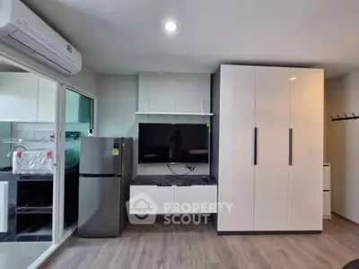 Modern apartment interior with sleek cabinetry and appliances, featuring a stylish open layout.