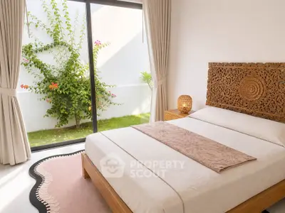 Elegant bedroom with carved wooden headboard and garden view, perfect for serene living.