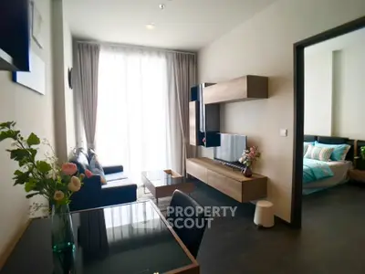 Modern living room with stylish decor and natural light, adjacent to a cozy bedroom.
