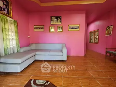 Vibrant pink living room with modern sectional sofa and framed art on walls.