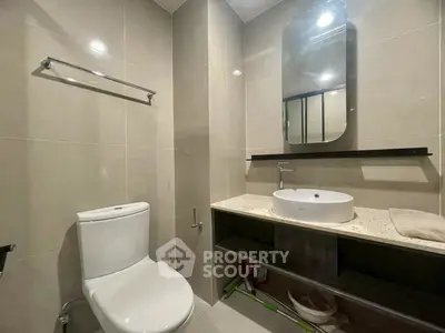 Modern bathroom with sleek fixtures and elegant design, featuring a stylish mirror and contemporary sink.