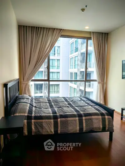 Modern bedroom with large window and stylish curtains in urban apartment