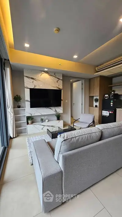 Modern living room with sleek design, large TV, and stylish furniture in a contemporary apartment.