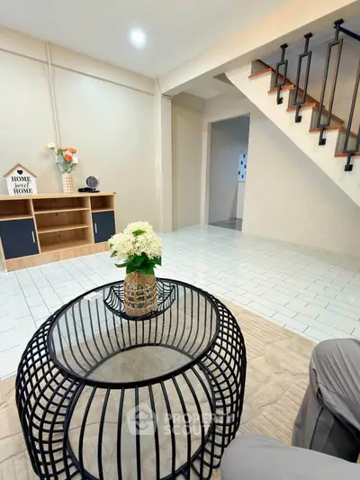 Charming living room with modern decor and stylish staircase in cozy home.
