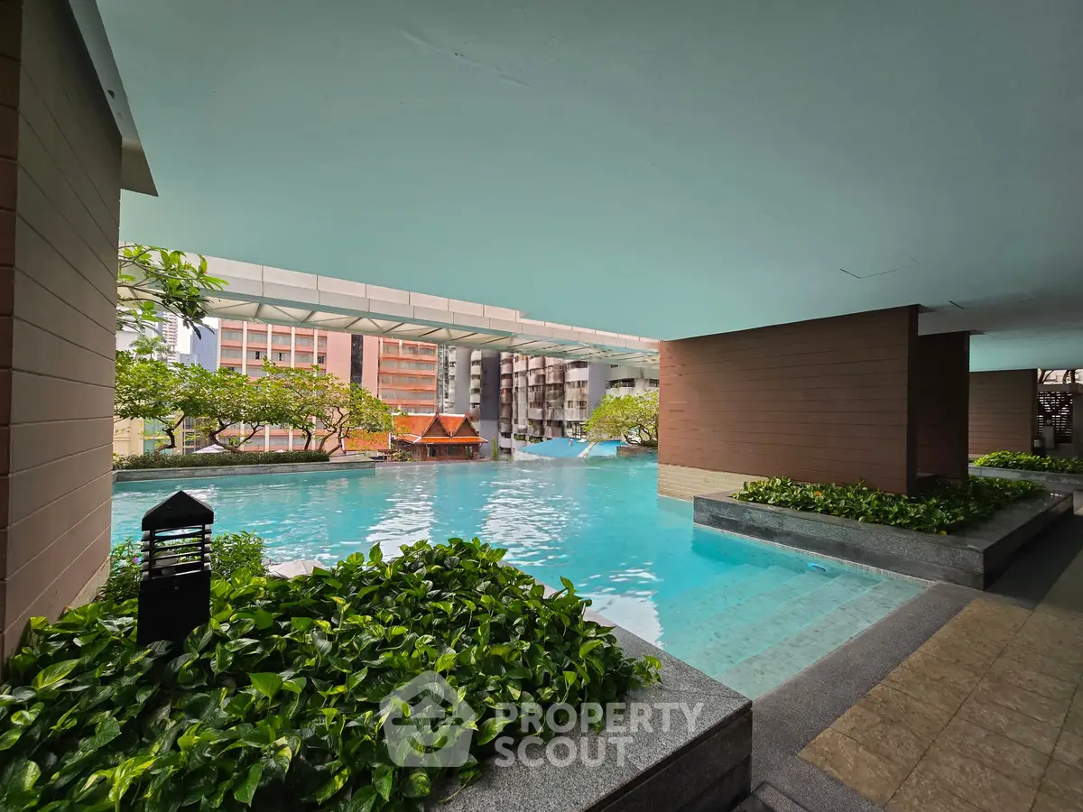 Luxurious apartment complex with stunning pool and lush greenery, perfect for relaxation and leisure.