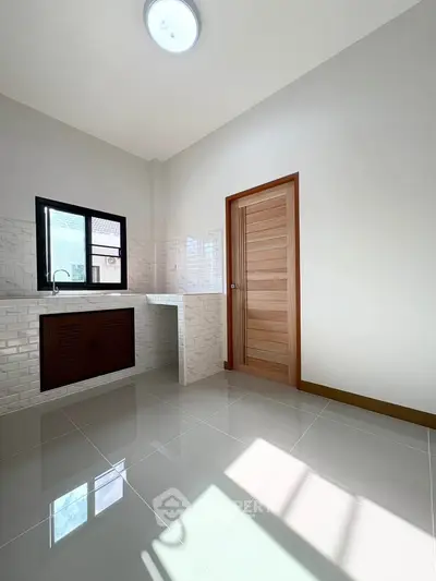 Bright and spacious kitchen with modern tile flooring and ample natural light.