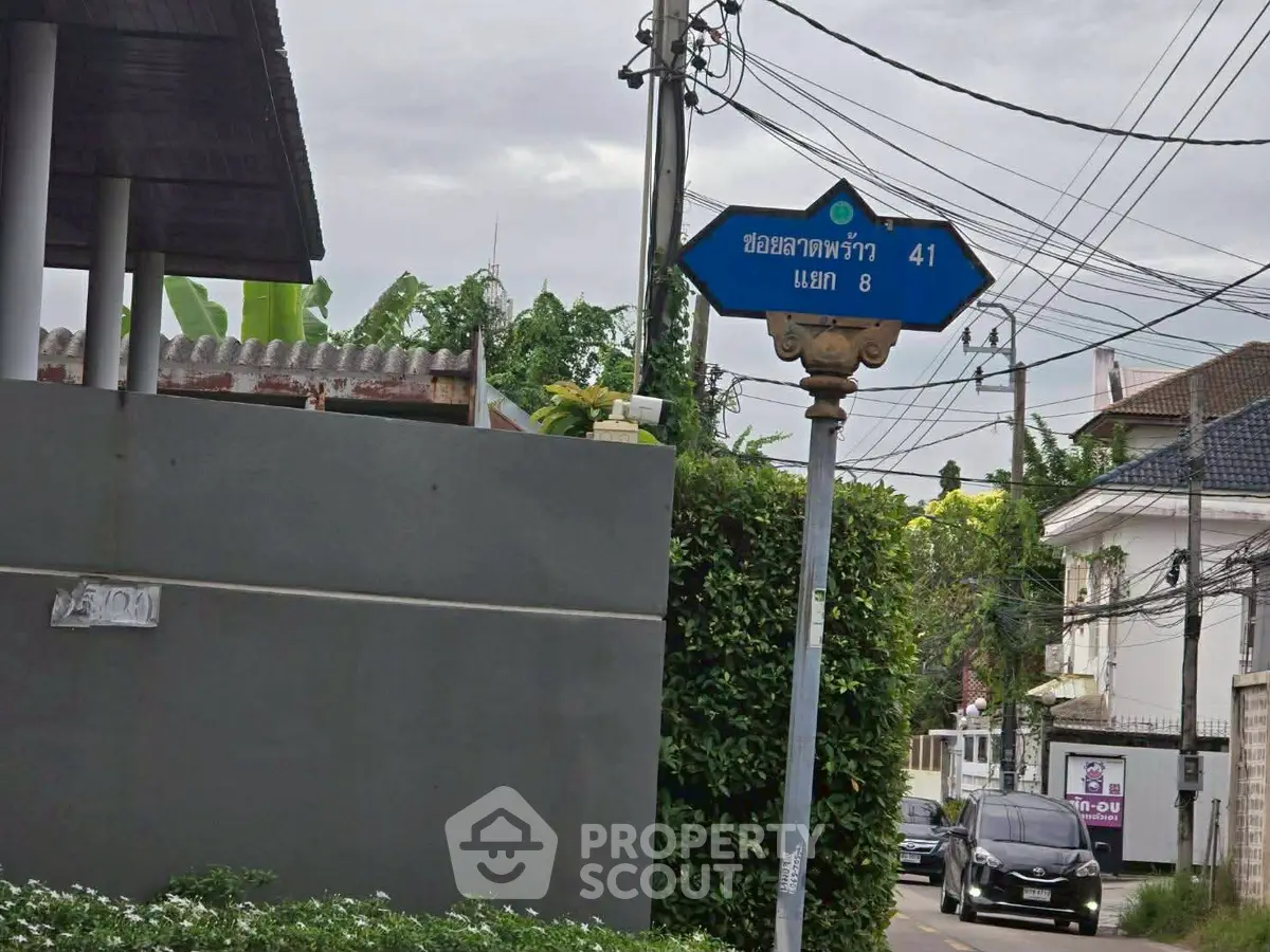 Charming residential street view with lush greenery and traditional architecture.