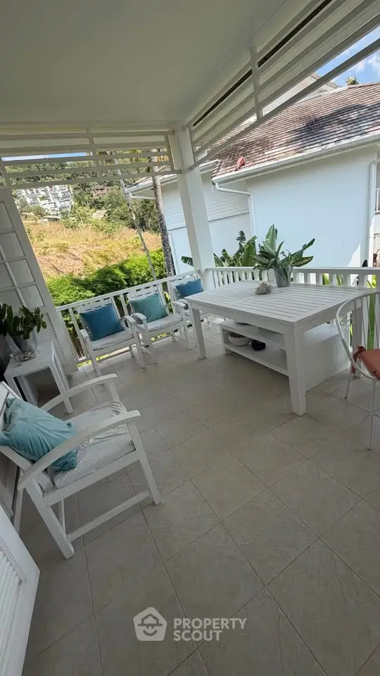 Charming balcony with cozy seating and lush greenery, perfect for relaxation and enjoying the view.