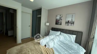 Modern bedroom with stylish decor and large window offering natural light.