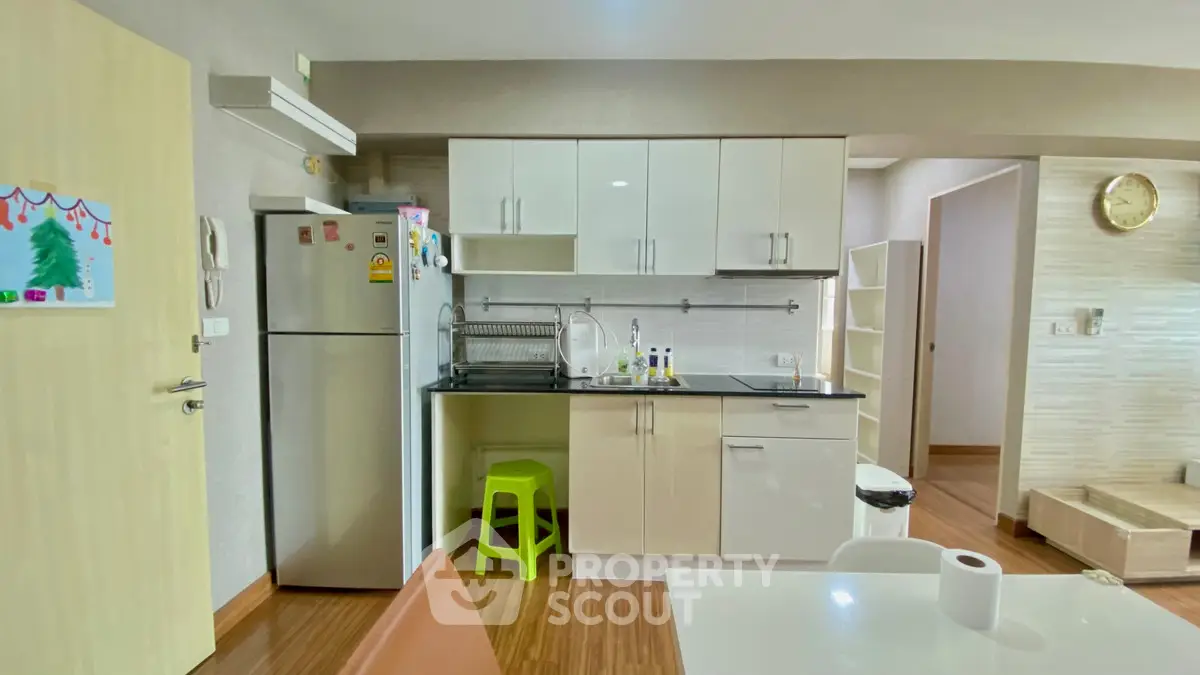 Modern kitchen with sleek cabinetry and stainless steel appliances in cozy apartment