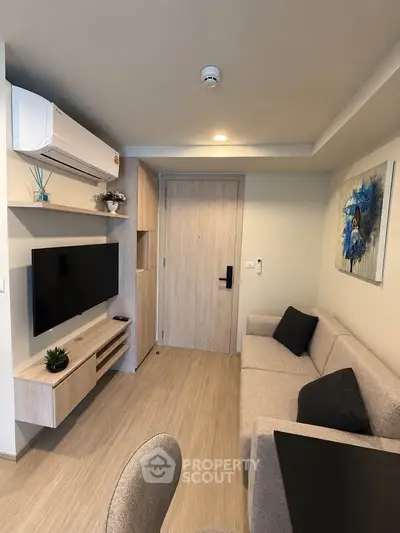 Modern living room with sleek design, featuring a wall-mounted TV and cozy sofa.