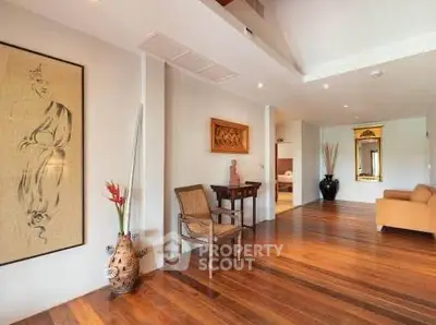 Spacious living area with elegant decor and wooden flooring in a modern home.