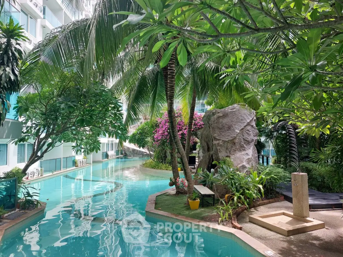 Luxurious tropical pool area with lush greenery and serene ambiance in a modern residential complex.