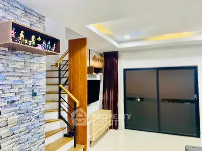 Modern living room with stylish staircase and decorative stone wall