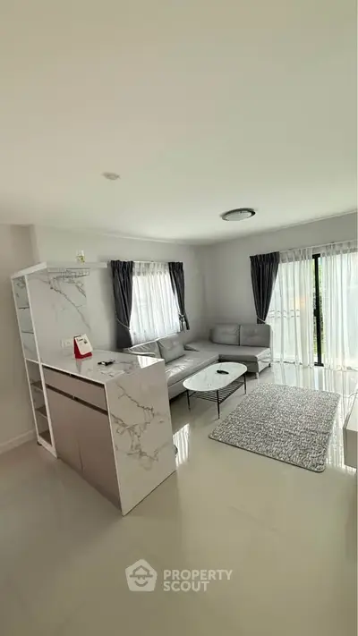 Modern living room with sleek marble accents and abundant natural light.