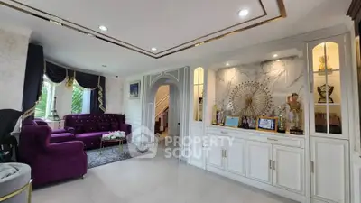 Luxurious living room with elegant decor and plush purple sofas, featuring a stylish archway and built-in display shelves.