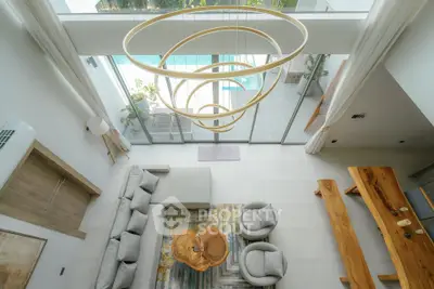 Stunning modern living room with pool view, featuring elegant furniture and unique lighting design.