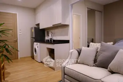 Modern apartment interior with cozy living room and sleek kitchen featuring washing machine and microwave.