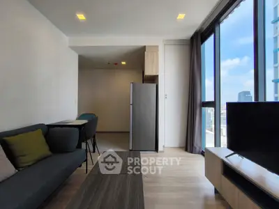 Modern living room with city view, featuring sleek furniture and large windows for natural light.