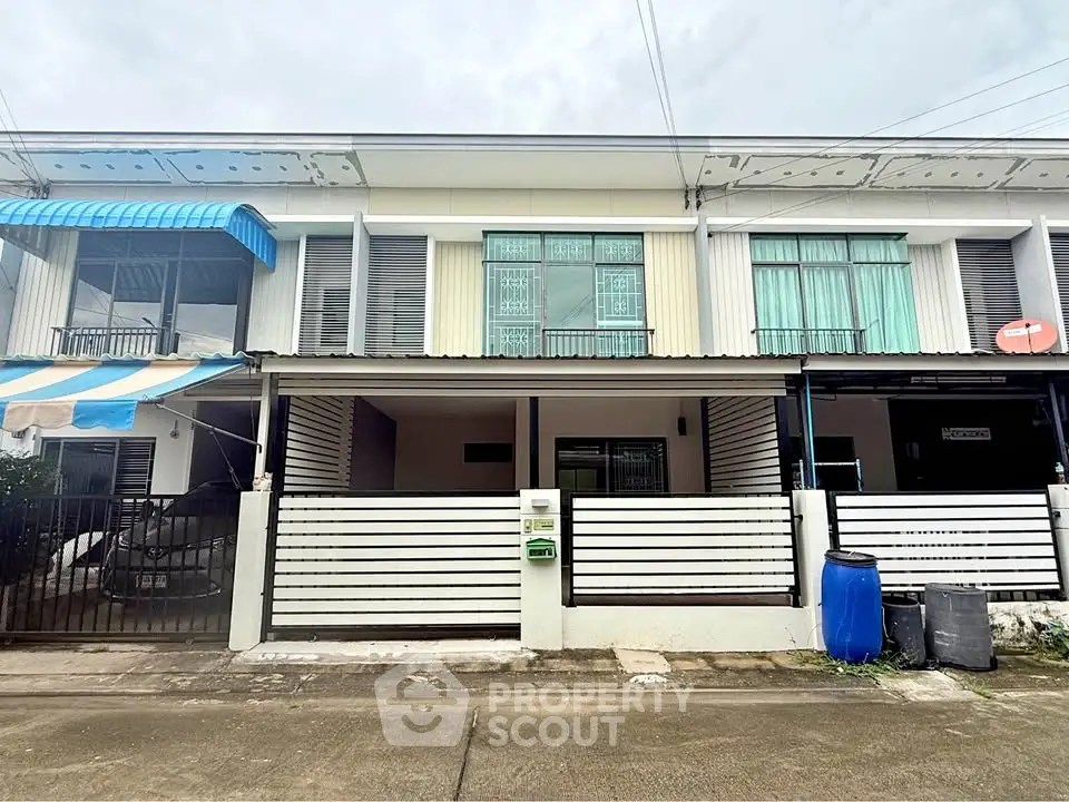 Charming townhouse exterior with modern facade and gated entrance in a serene neighborhood.