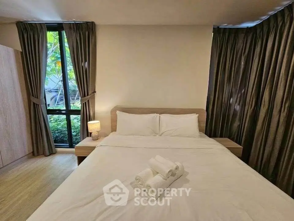 Cozy bedroom with large window and elegant curtains, perfect for relaxation and comfort.