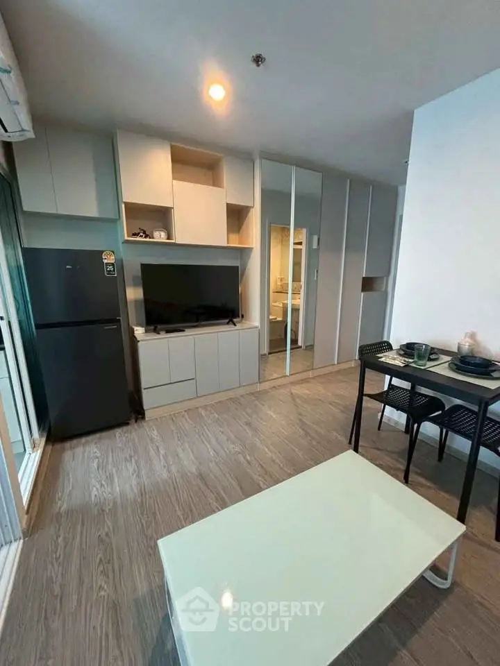 Modern living room with sleek furniture and open kitchen layout in a stylish apartment.