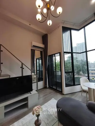 Modern living room with high ceiling and large windows offering city views