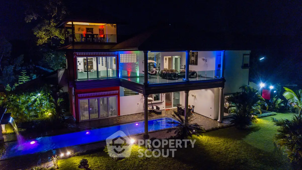 Luxurious modern villa with illuminated pool and lush garden at night, showcasing stunning architectural design.
