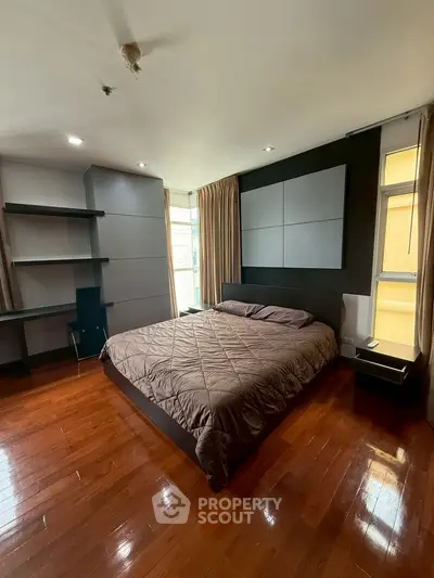 Spacious bedroom with modern design and hardwood floors in a luxurious apartment.