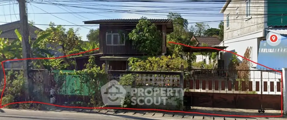 Charming rustic wooden house with lush greenery and gated entrance in a serene neighborhood.