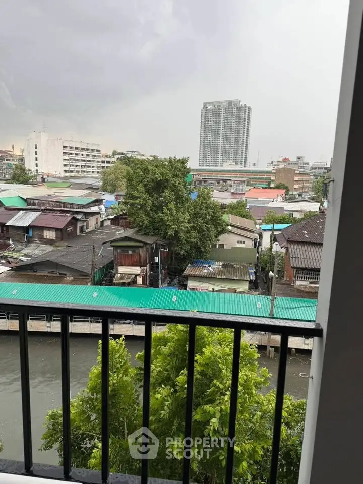 Scenic urban view from balcony overlooking canal and city skyline.