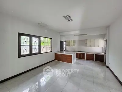 Spacious kitchen with modern cabinetry and large windows offering natural light.
